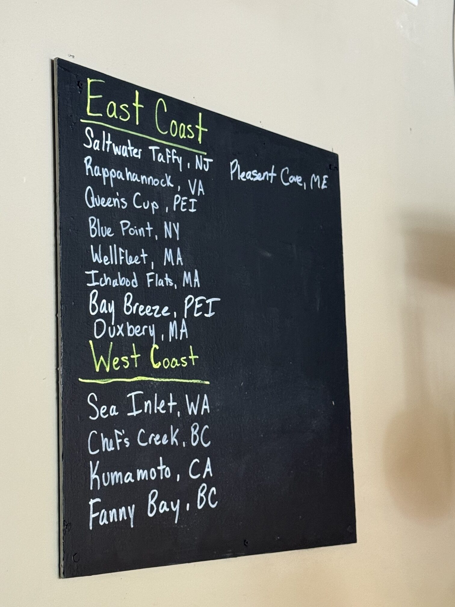 The handwritten East and West Coast oyster board at EDWINS